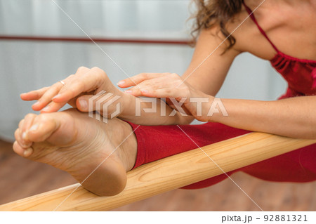 A choreographer in a red jumpsuit is engaged near the machine, in the choreographic hall. A choreographer in a red jumpsuit is engaged near the machine, in the choreographic hall. 92881321