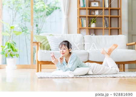 リビングでスマホを見る若い女性 リビングでスマホを見る若い女性 92881690