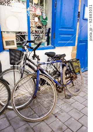 歩道わきで建物に立てかけられた年季の入った自転車　モロッコの海沿いの街エッサウィラにて 92883031