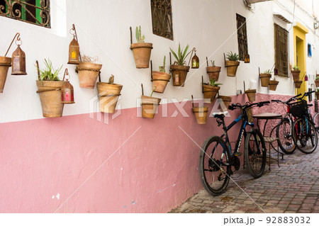 城と赤茶色の壁に吊り下げられた植木鉢と建物脇に置かれた自転車　モロッコの海沿いの街エッサウィラにて 92883032
