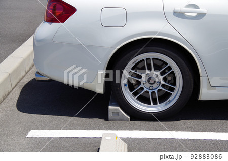 バック駐車した乗用車の後輪が駐車場の車止めに当たった状態 バック駐車した乗用車の後輪が駐車場の車止めに当たった状態 92883086