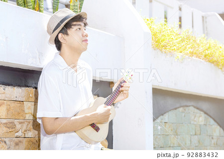 Asian man with hat playing guitar ukulele Asian man with hat playing guitar ukulele 92883432