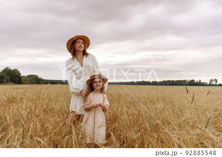 Mom and daughter in a wheat field 92885548