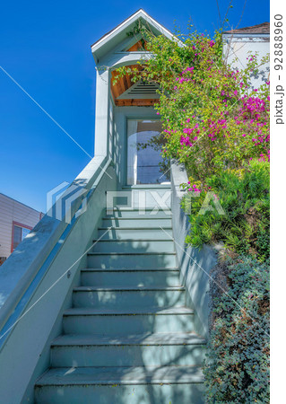 Home entrance with stairs near shrubs leading to a porched with picture windows at San Francisco, CA 92888960