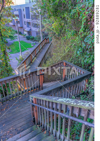 Weathered wood stairs and boardwalk near the slope with plants- San Francisco, CA Weathered wood stairs and boardwalk near the slope with plants- San Francisco, CA 92889281