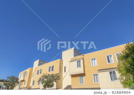 Exterior of an apartment building with beige and yellow wood lap siding in San Francisco, California 92889904
