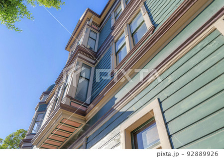 Low angle view of a victorian residential building with green wood lap sidings in San Francisco, CA Low angle view of a victorian residential building with green wood lap sidings in San Francisco, CA 92889926