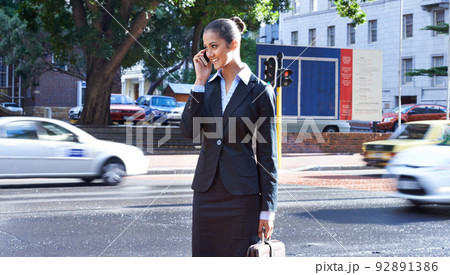 Keeping connected on the go. A shot of a young businesswoman talking on her cellphone in the city. 92891386