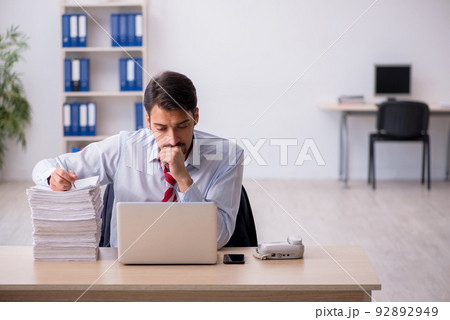 Young male employee sitting at workplace Young male employee sitting at workplace 92892949
