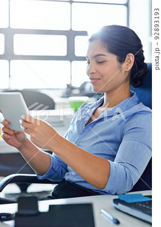 Connecting with a client online. Shot of a young businesswoman using a digital tablet at work. Connecting with a client online. Shot of a young businesswoman using a digital tablet at work. 92893193