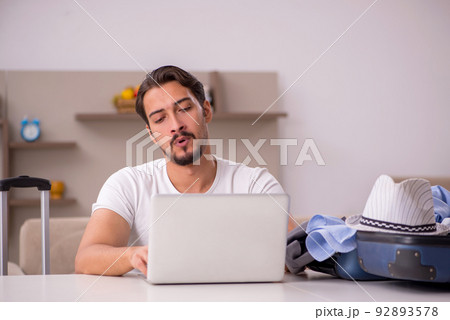 Young man preparing for trip at home 92893578