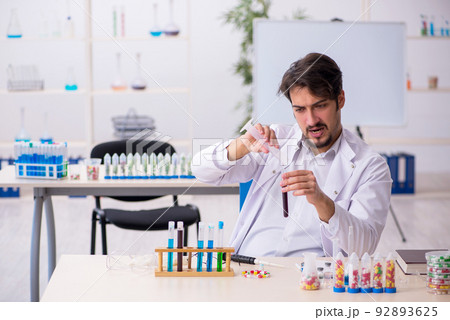 Young male chemist in drugs synthesis concept 92893625