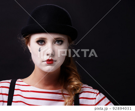 Allow me to mime a sad story. Studio shot of a female mime. 92894031