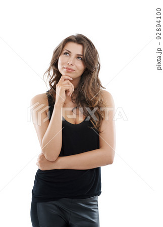 Considering all the possibilities. Gorgeous young woman smiling while looking thoughtful and isolated on white. 92894100