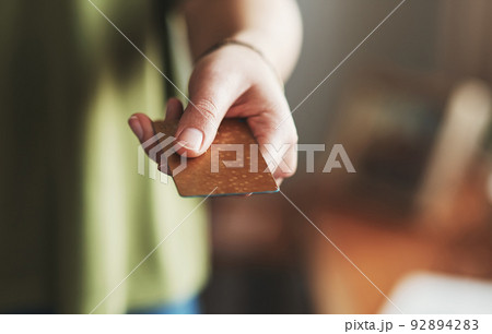 Take my money. Cropped shot of an unrecognizable businesswoman standing alone in her home office and holding out her credit card. 92894283
