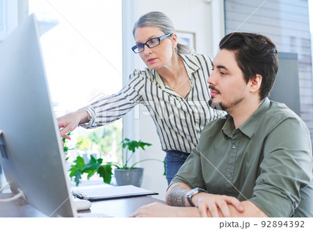 Merging all the ideas they have. Shot of two businesspeople working together on a computer in an office. Merging all the ideas they have. Shot of two businesspeople working together on a computer in an office. 92894392