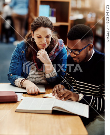 Turn to the next page. Shot of a group of university students working in the library at campus. 92894725