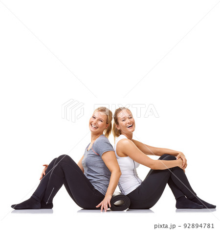Taking the fitness journey together. Two gym friends sitting back to back while isolated on a white background. 92894781