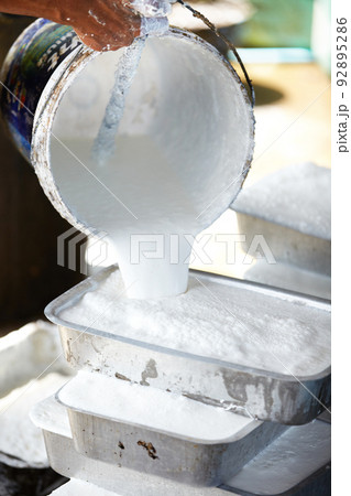 A delicate process. A Thai man pouring liquid rubber into moulds to set. A delicate process. A Thai man pouring liquid rubber into moulds to set. 92895286