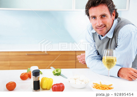 Confident mature man standing in kitchen. Portrait of a confident mature man standing in the kitchen. Confident mature man standing in kitchen. Portrait of a confident mature man standing in the kitchen. 92895454