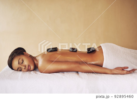 Stones of serenity. Cropped shot of a young woman enjoying some lastone therapy at the spa. Stones of serenity. Cropped shot of a young woman enjoying some lastone therapy at the spa. 92895460