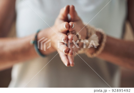 Balancing my chakras. Cropped shot of an unrecognizable woman standing with her palms together while meditating indoors. Balancing my chakras. Cropped shot of an unrecognizable woman standing with her palms together while meditating indoors. 92895492