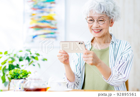 スマホで動画を見るシニア女性 92895561
