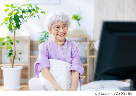 笑顔でテレビを見るシニア女性 92895566