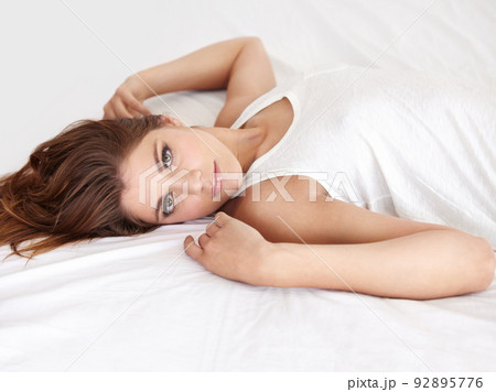 Her natural beauty is hypnotic. A gorgeous young woman lying on her bed in a sleepshirt. Her natural beauty is hypnotic. A gorgeous young woman lying on her bed in a sleepshirt. 92895776
