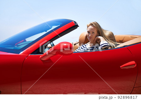 Symbol of success.... Shot of a young woman driving in a sports car. 92896817