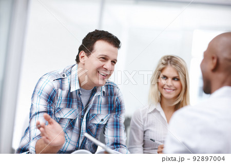 He is confident in his team members abilities. A group of professionals having a work discussion. He is confident in his team members abilities. A group of professionals having a work discussion. 92897004