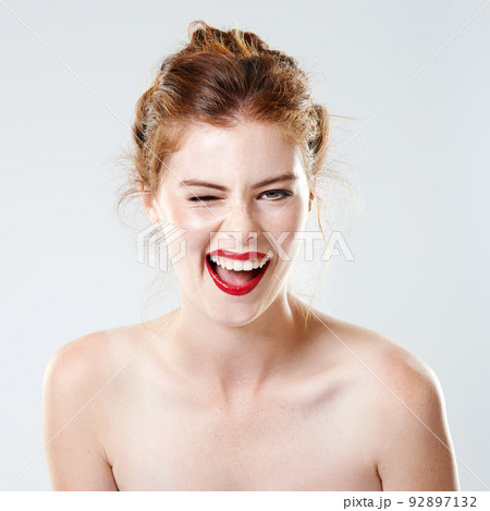 When in doubt... wear red. Studio shot of a beautiful young woman with bare shoulders winking at the camera. When in doubt... wear red. Studio shot of a beautiful young woman with bare shoulders winking at the camera. 92897132