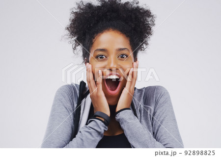 What a surprise. Studio portrait of an attractive young woman looking surprised against a grey background. What a surprise. Studio portrait of an attractive young woman looking surprised against a grey background. 92898825