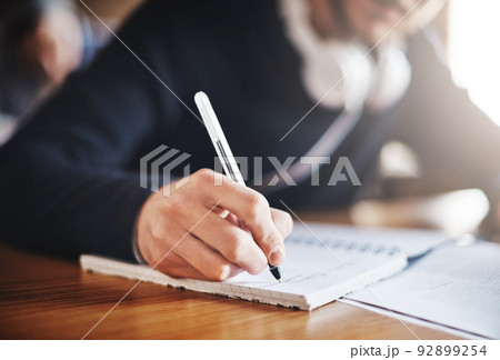 Take notes now and study hard later. Cropped shot of an unrecognizable male university student in class. 92899254