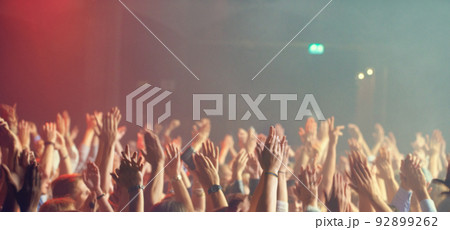 A crowd of people celebrating and partying with their hands in the air to an awesome band. This concert was created for the sole purpose of this photo shoot, featuring 300 models and 3 live bands. All 92899262