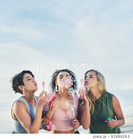 Just be bubbly. Cropped shot of three friends blowing bubbles at the beach. Just be bubbly. Cropped shot of three friends blowing bubbles at the beach. 92899263
