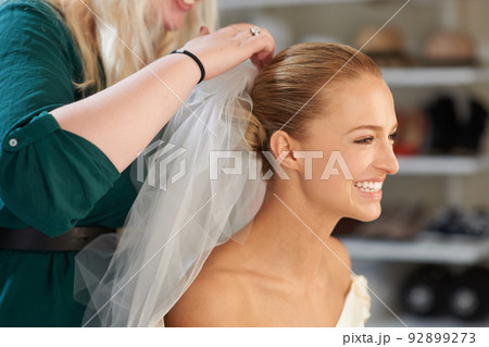 Placing those finishing touches. A young bride getting her hair done before the wedding. Placing those finishing touches. A young bride getting her hair done before the wedding. 92899273