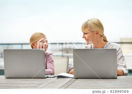 Just like her mom. Shot of a young girl and her mother using laptops side by side. Just like her mom. Shot of a young girl and her mother using laptops side by side. 92899569