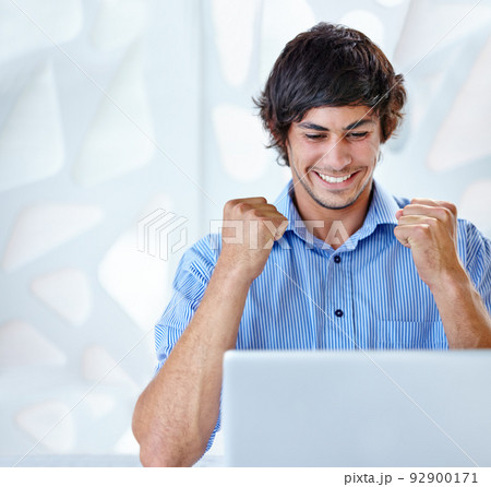 I got that promotion. Shot of an ecstatic young businessman sitting in front of her laptop. 92900171