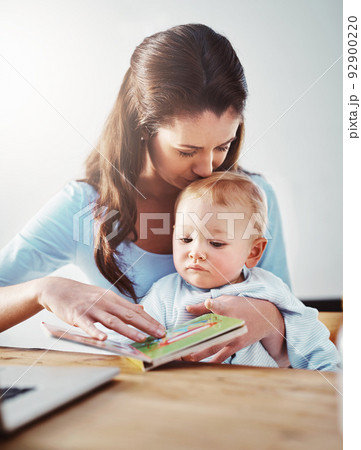 Reading time for baby. Shot of a mother and her baby boy at home. 92900220