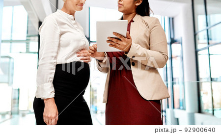 You can expect big results by working together. Shot of two businesswomen using a digital tablet together in an office. 92900640