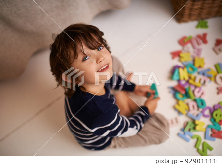 Imagination is the beginning of creation. Portrait of an adorable little boy playing with colorful toy letters. 92901111