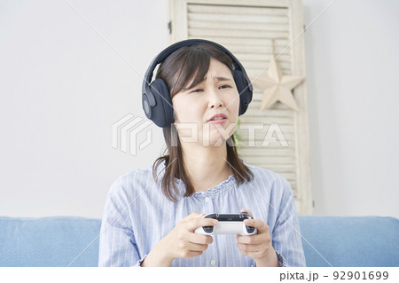 自宅で一人でテレビゲームをして落ち込む女性 自宅で一人でテレビゲームをして落ち込む女性 92901699
