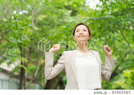 新緑の中で微笑む女性 新緑の中で微笑む女性 92903565