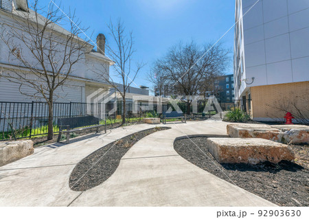 Pathway with benches and large concrete blocks on the side near the buildings at San Antonio, Texas 92903630