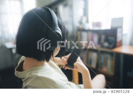 Young adult asian woman wear headphone listen music and relax at home Young adult asian woman wear headphone listen music and relax at home 92905126