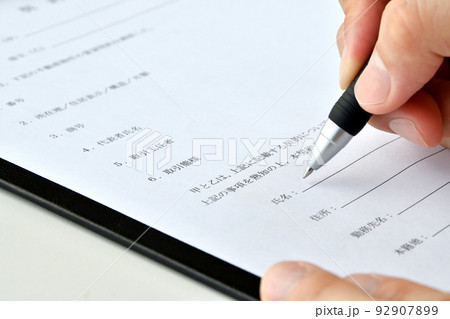 契約書にサインをする人物の手元 92907899