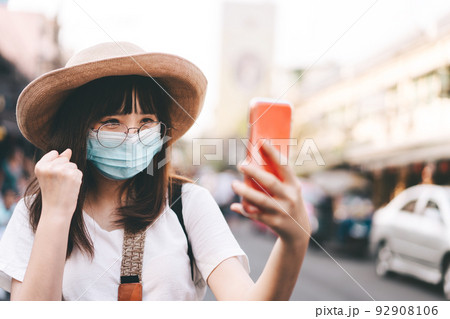 Young asian traveller influencer use mask protect virus and live with smartphone Young asian traveller influencer use mask protect virus and live with smartphone 92908106