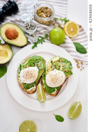 Freshly made poached egg and Avocado toasts on light grey background Freshly made poached egg and Avocado toasts on light grey background 92908609