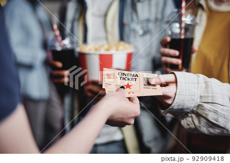 Unrecognizable people giving tickets for movie to cinema worker to enter hall, selective focus shot 92909418